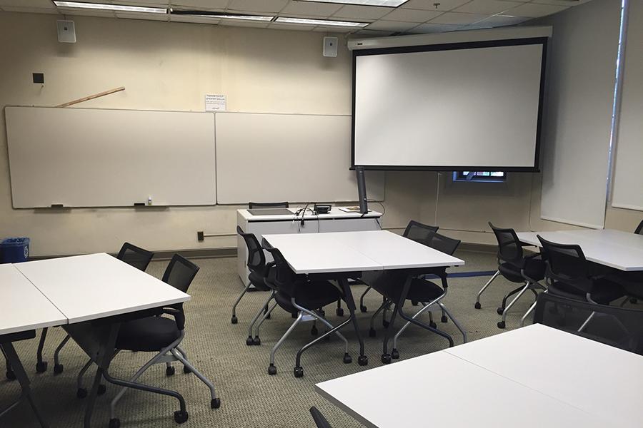 布特里克教室里有桌子、投影屏幕和白板